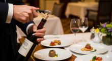 Un sommelier stappa una bottiglia di vino in un elegante ristorante italiano